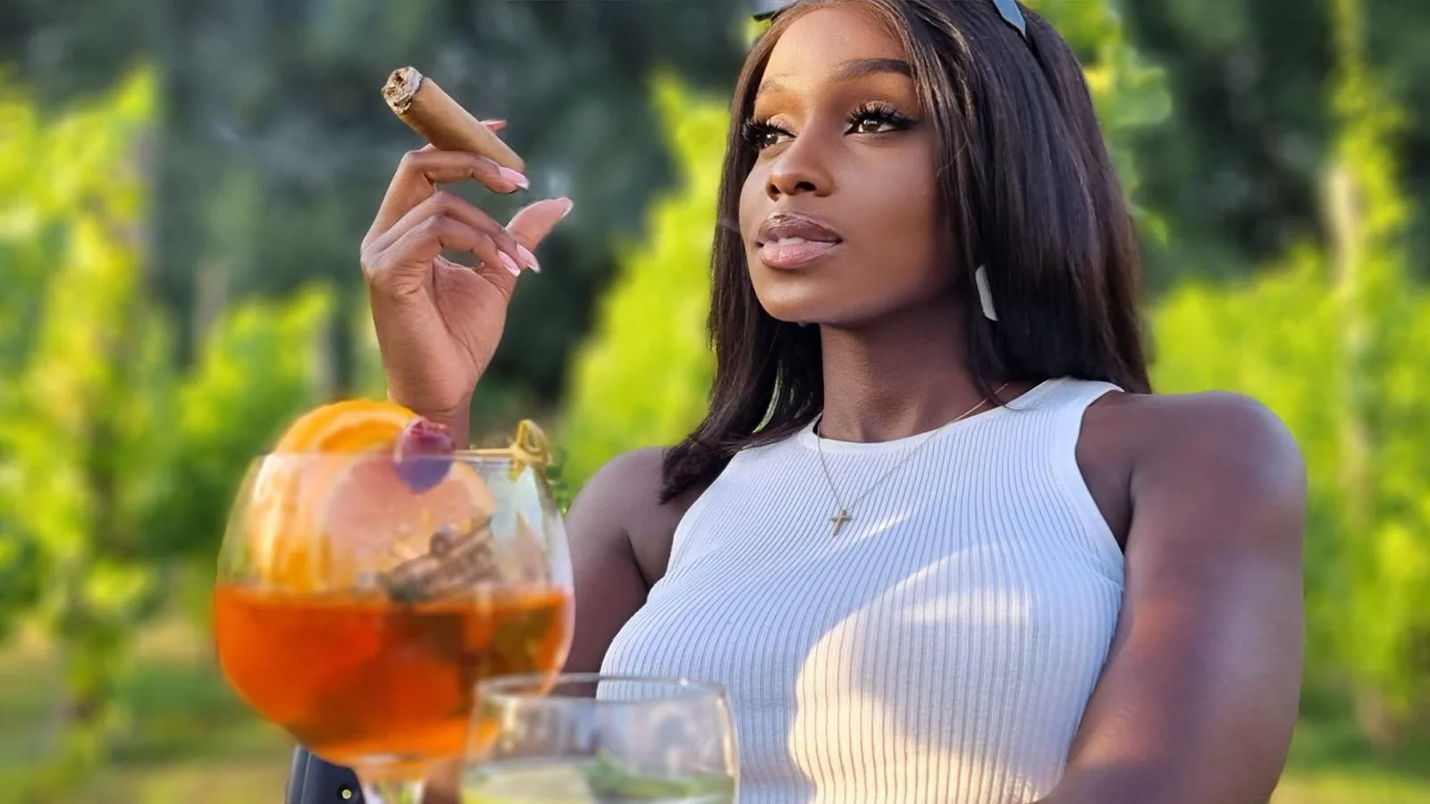 June in a white ribbed tank top in a vineyard at sunset